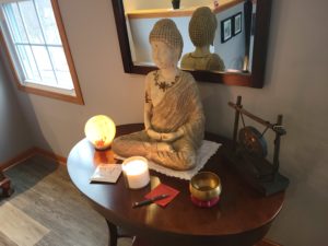 Image: Buddha, salt lamp, wish paper, candle, pen, and bowl on a table