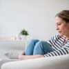 woman sitting on the couch looking depressed or contemplative