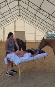 Denise giving Reiki to a woman surrounded by horses